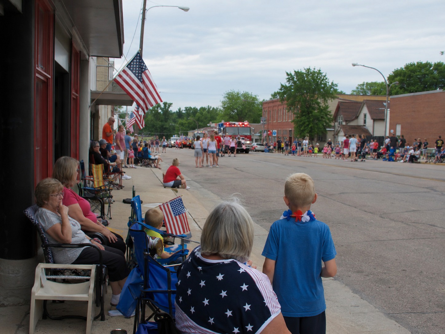 Residents line Main Street ahead of a small-town Fourth of July parade.